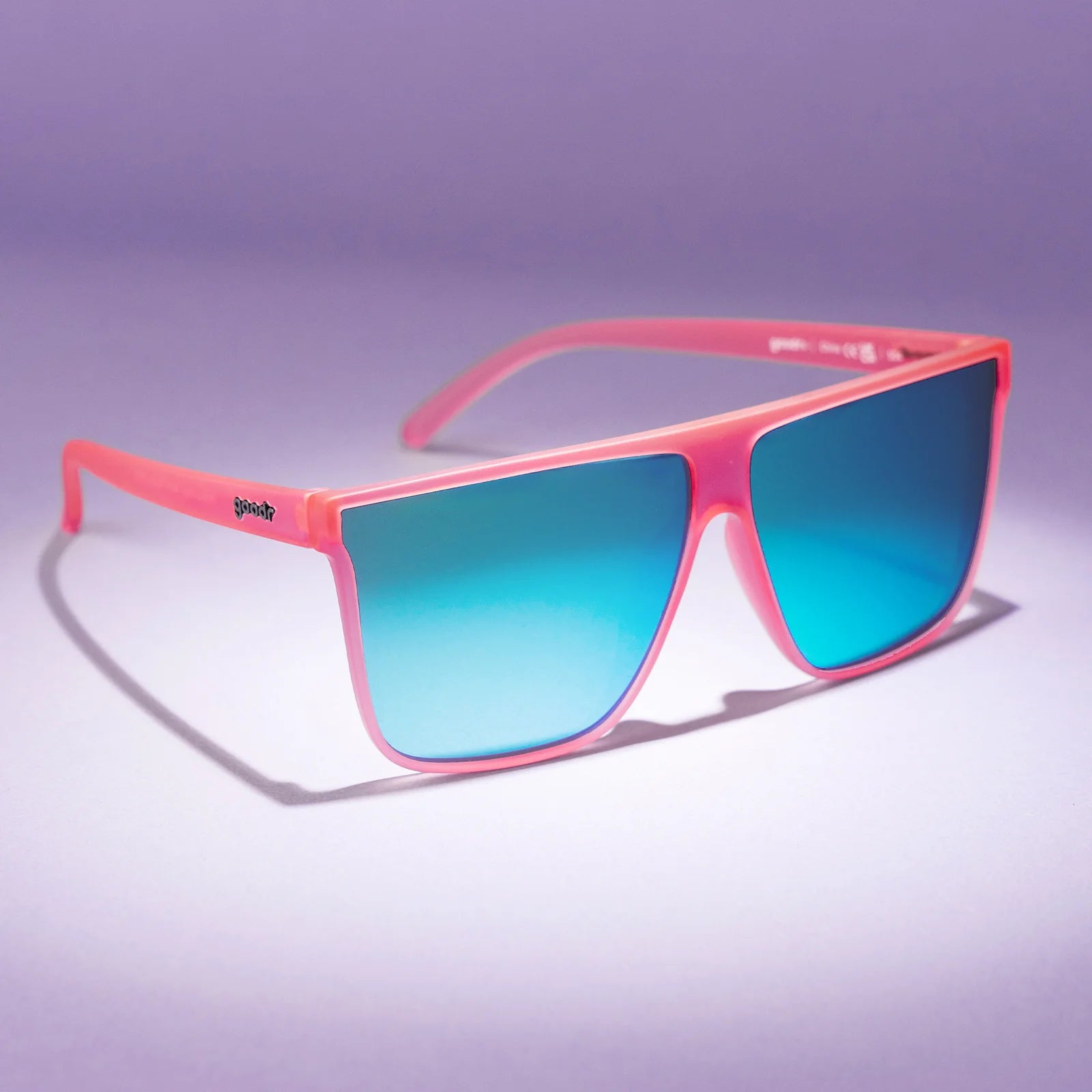 Hot pink translucent frames with teal reflective lenses. Wider-fit, flat-top sunglasses