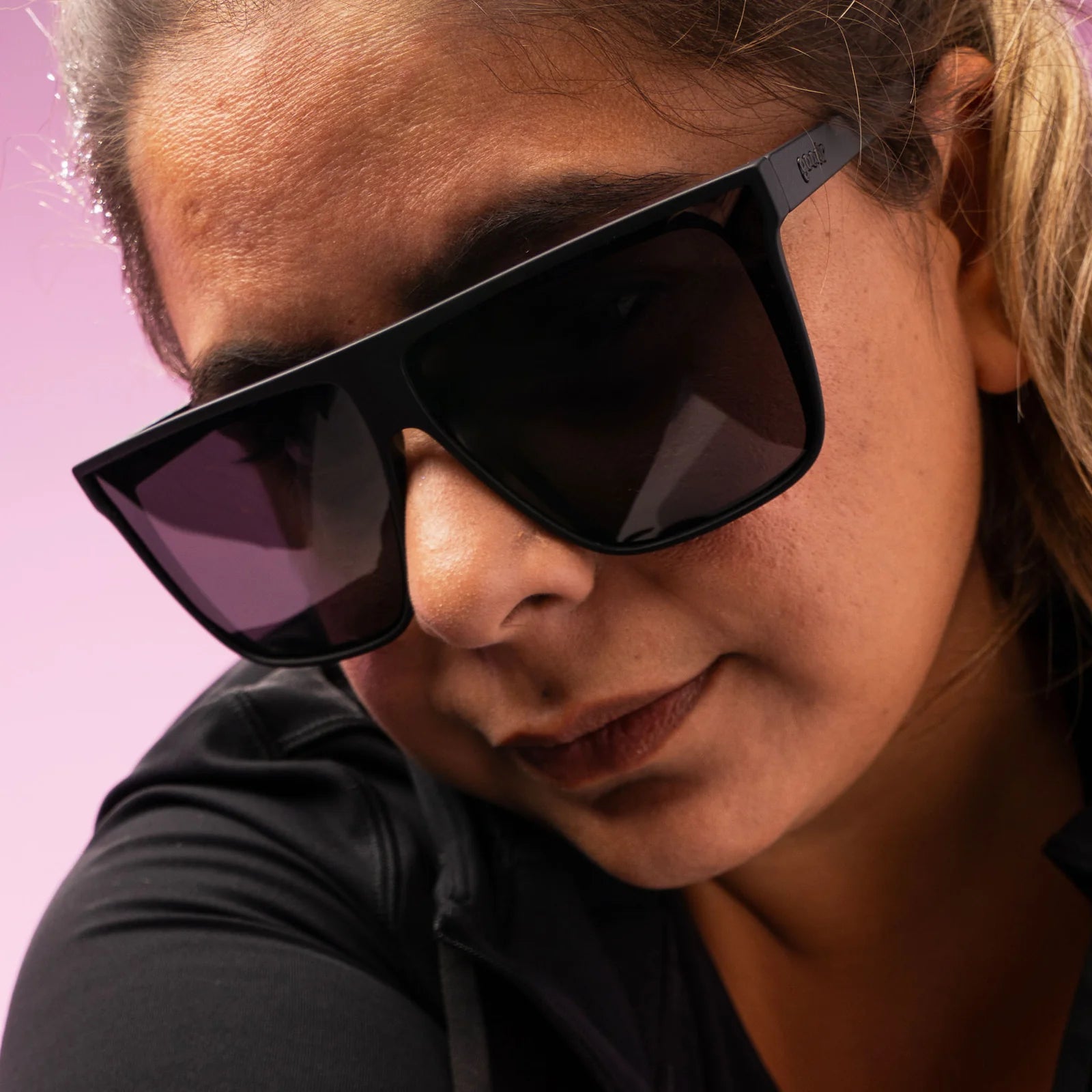 Style and fit showcase of black wide-fit, oversized sunglasses with non-reflective lenses.